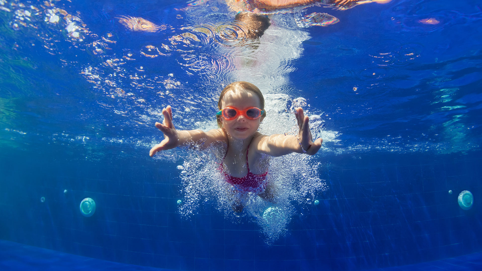Schwimmendes Kind mit Taucherbrille unter Wasser 