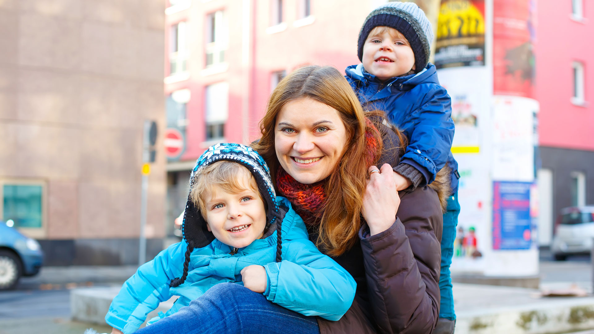 Eine Mutter ist im Winter mit ihren beiden Kindern in Berlin unterwegs.