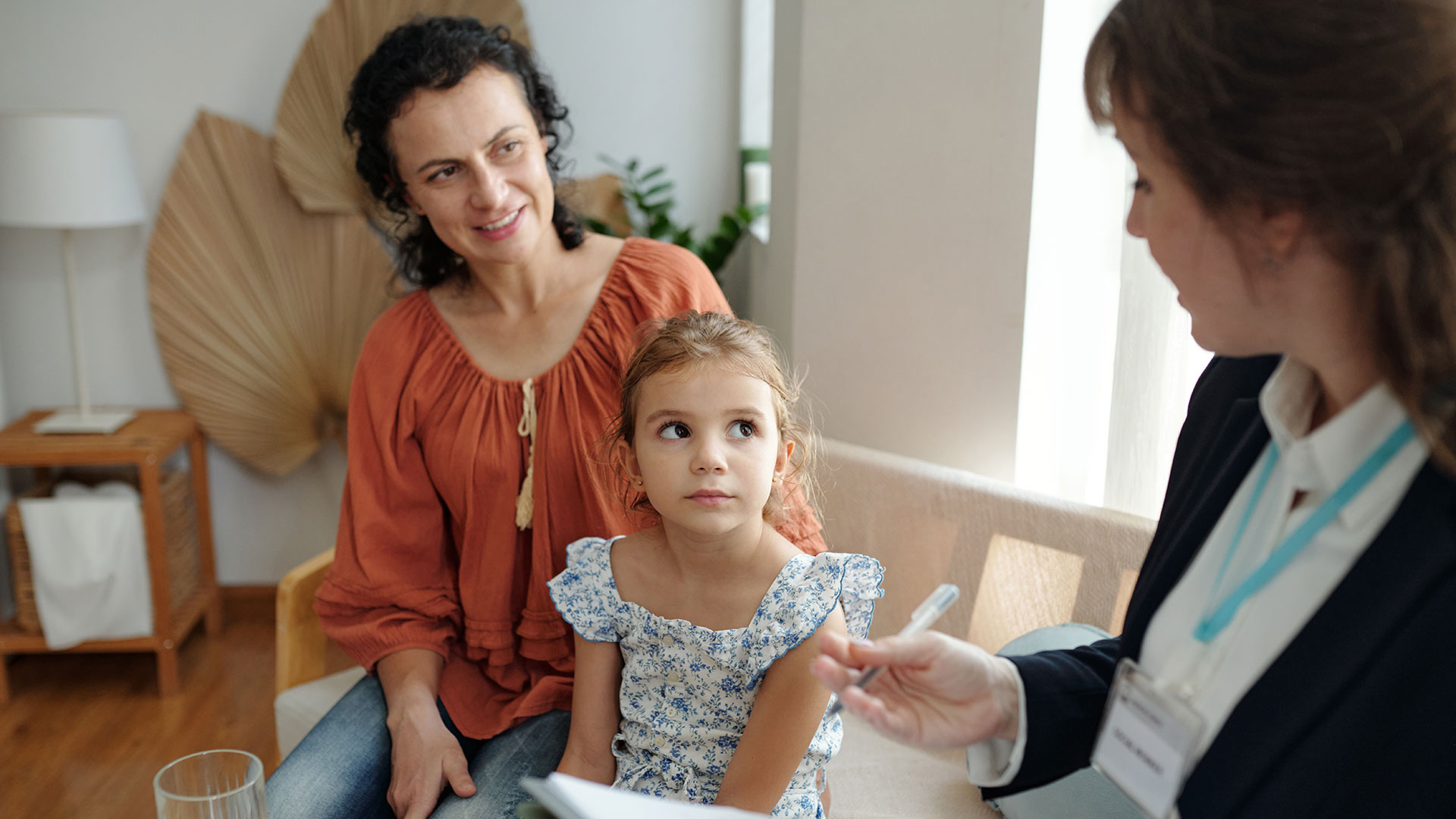 Eine Sozialarbeiterin besucht eine Mutter und ihre Tochter zu Hause.