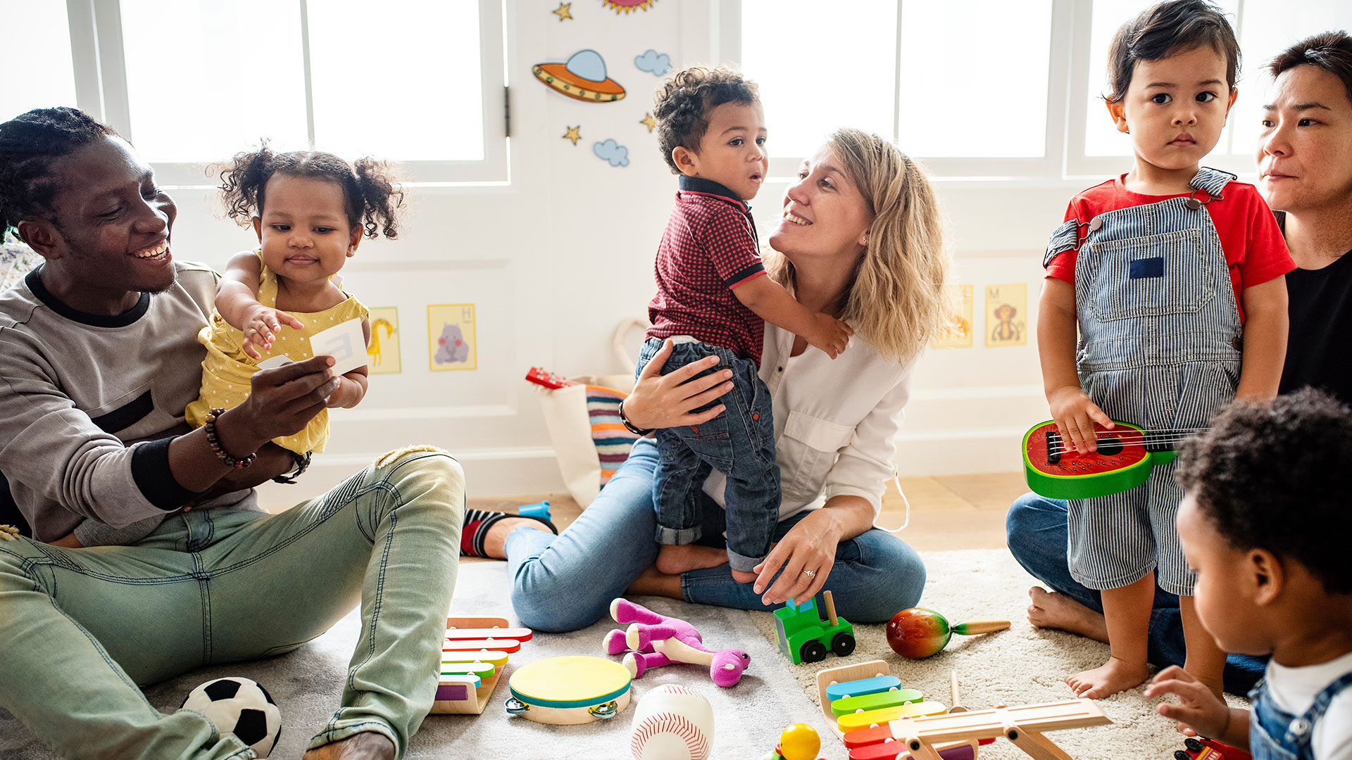 Eltern spielen mit ihren Kindern in einer Spielgruppe.