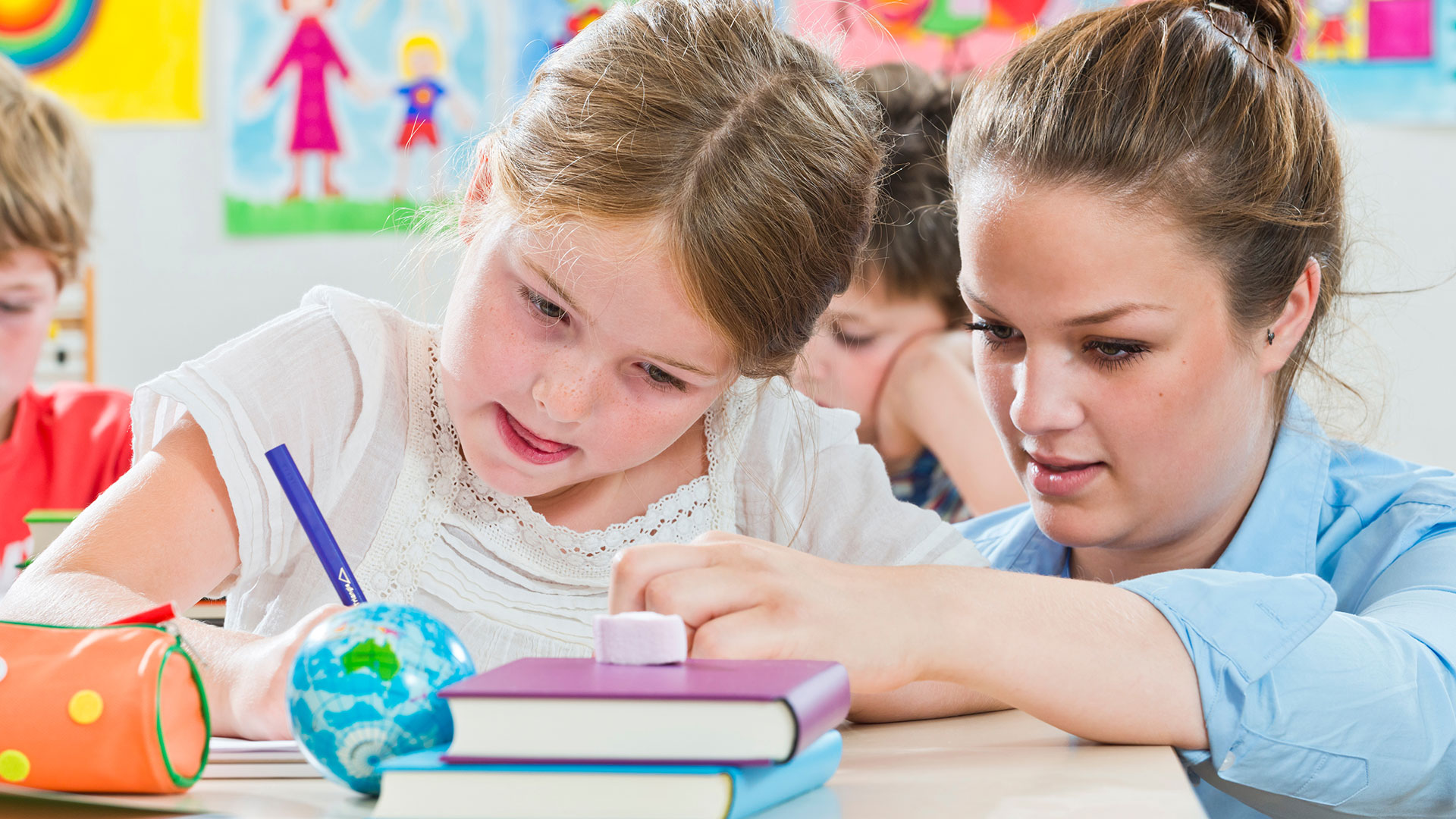 Junges Mädchen erhält Lernunterstützung von einer Lehrerin