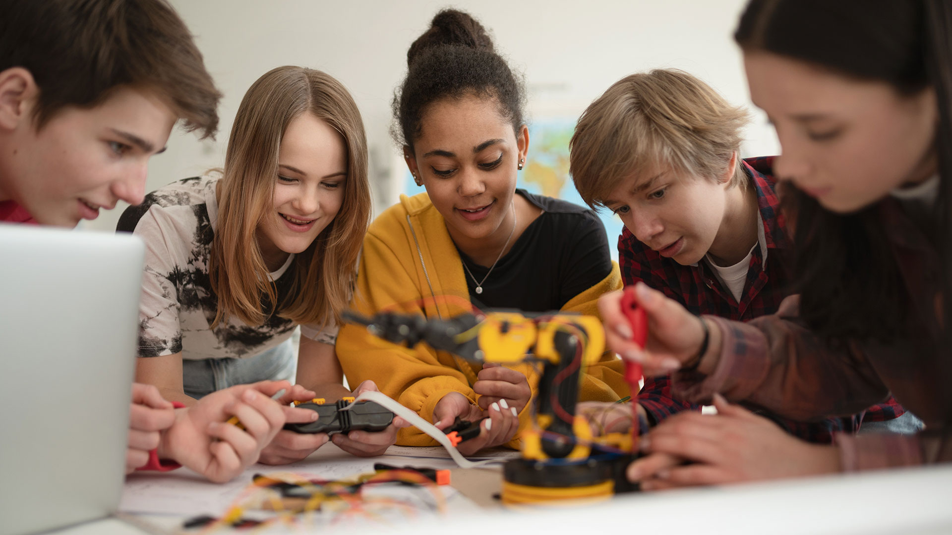 Eine Gruppe Kinder baut im Unterricht an einem fernsteuerbaren Roboter.