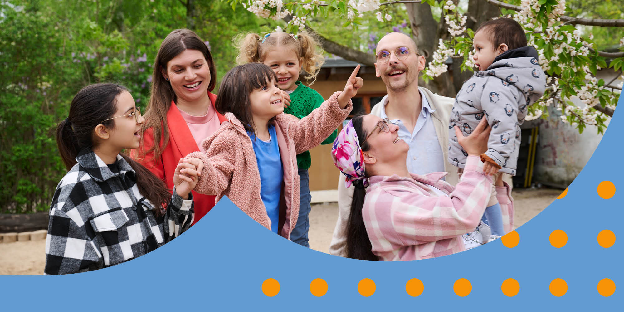 Eine gemischte Gruppe Eltern steht mit ihren Kindern auf einem Spielplatz.