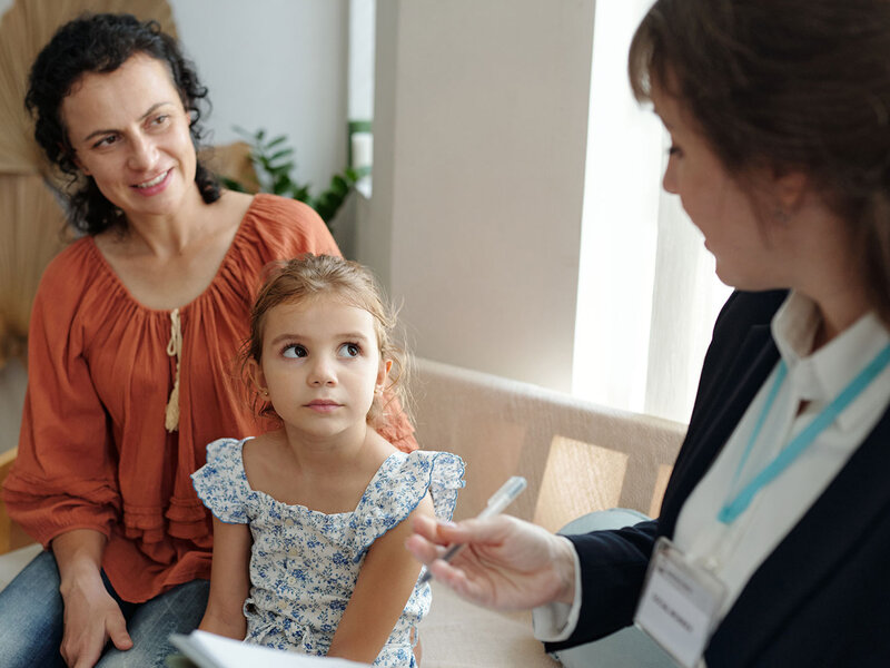 Eine Sozialarbeiterin besucht eine Mutter und ihre Tochter zu Hause.