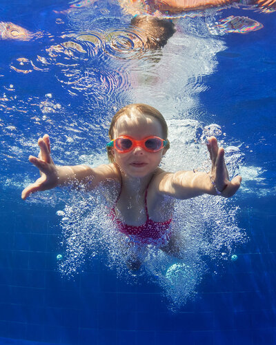 Schwimmendes Kind mit Taucherbrille unter Wasser 